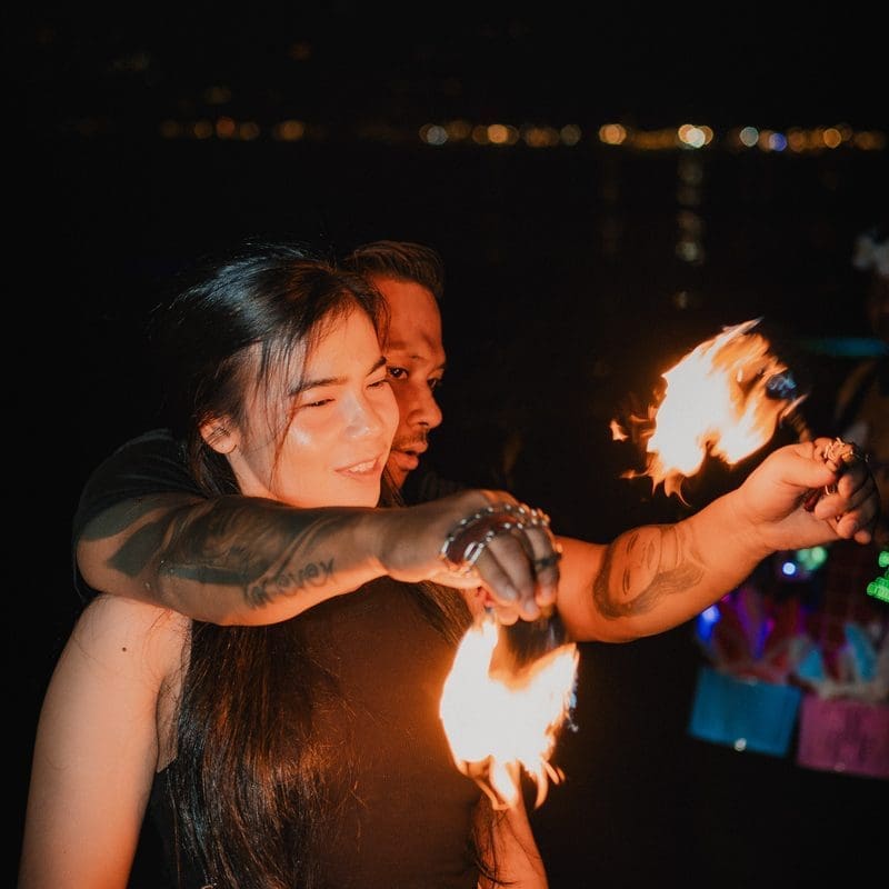A fire dancer working the crowd on the sand at ARKbar on New Year&rsquo;s Eve