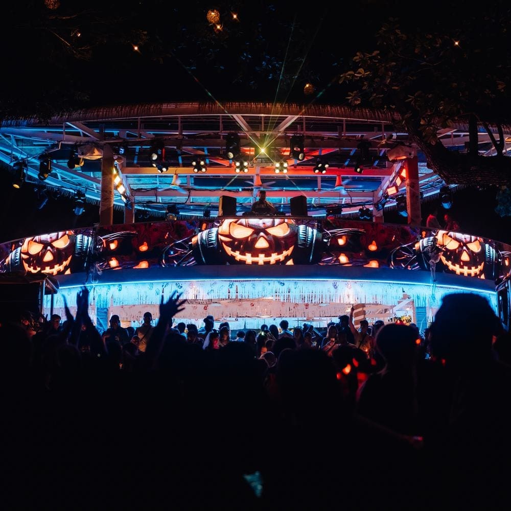 The ARKbar DJ booth lit orange with pumpkins along the front on Halloween 2024